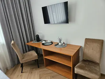 a room with a desk and a chair and a mirror at Svečių namai RASA in Raseiniai