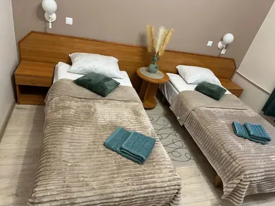 two beds in a room with green pillows on them at Svečių namai RASA in Raseiniai