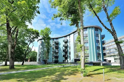 a building with trees in front of it at Valensia Apartment in Druskininkai