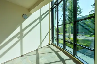 an empty room with windows and a clock on the wall at Valensia Apartment in Druskininkai