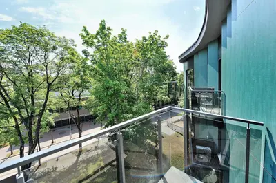 a balcony with a glass railing next to a building at Valensia Apartment in Druskininkai
