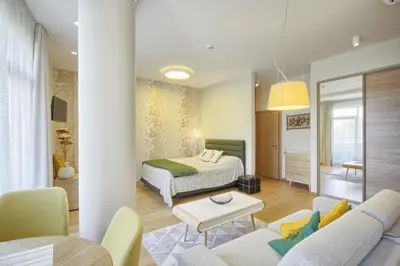 a hotel room with a bed and a living room at Valensia Apartment in Druskininkai