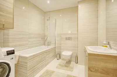 a bathroom with a tub and a toilet and a sink at Valensia Apartment in Druskininkai
