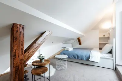 a attic bedroom with a bed and a staircase at #stayhere - Light Vilnius views Loft City Center in Vilnius