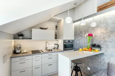 a kitchen with white cabinets and a white counter top at #stayhere - Light Vilnius views Loft City Center in Vilnius