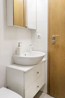 a white bathroom with a sink and a mirror at #stayhere - Light Vilnius views Loft City Center in Vilnius