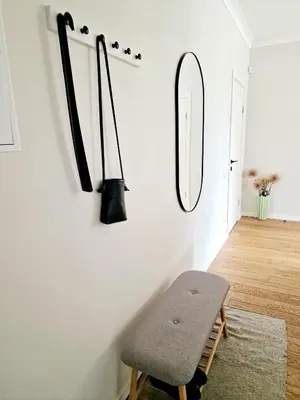 a room with a bench and a mirror on the wall at Central Stay Appartments in Šiauliai