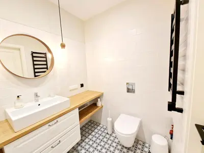 a bathroom with a sink and a toilet and a mirror at Central Stay Appartments in Šiauliai