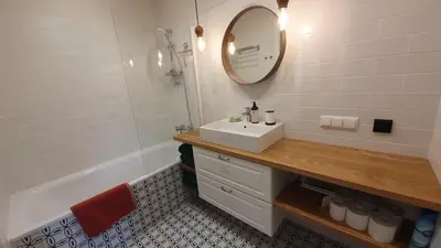 a bathroom with a sink and a mirror and a tub at Central Stay Appartments in Šiauliai