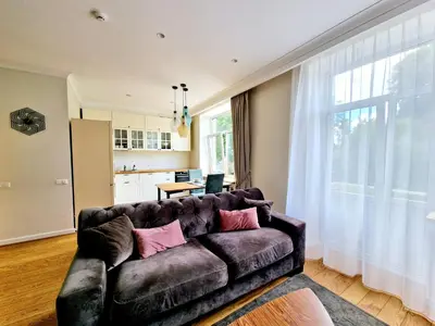 a living room with a couch with pink pillows at Central Stay Appartments in Šiauliai