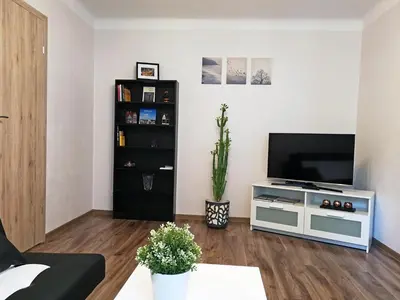 a living room with a flat screen tv on a stand at Šiauliai Central Spot Apartment - Draugystes pr. in Šiauliai