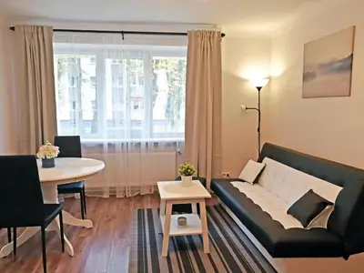 a living room with a couch and a table at Šiauliai Central Spot Apartment - Draugystes pr. in Šiauliai