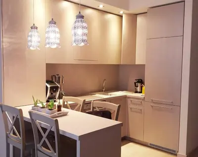 a kitchen with white cabinets and a table and chairs at Antakalnis Apartment in Vilnius
