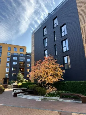 a black building with a tree in front of it at Antakalnis Apartment in Vilnius