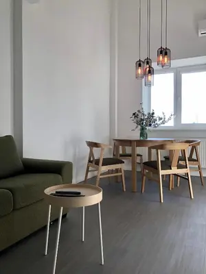 a living room with a couch and a table and chairs at COMFY Patogūs namai in Kaunas