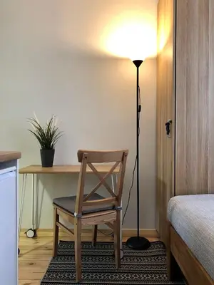 a room with a chair and a desk with a lamp at COMFY Patogūs namai in Kaunas
