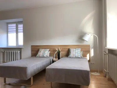 a bedroom with two beds and a lamp at COMFY Patogūs namai in Kaunas