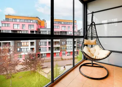 a hammock in a room with a large window at Ona`s apartment in City Center with private parking in Kaunas