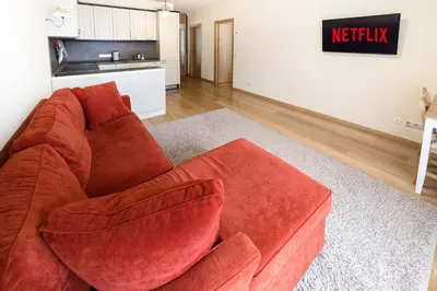a red couch sitting in a living room at Ona`s apartment in City Center with private parking in Kaunas