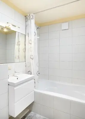 a white bathroom with a tub and a sink at Ona`s apartment in City Center with private parking in Kaunas