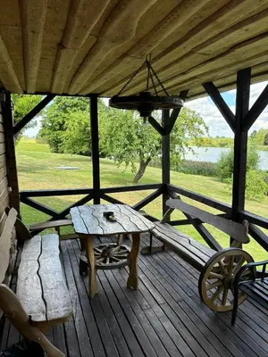 a wooden porch with a wooden table and a bench at Homestead 
