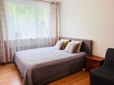 a bedroom with a bed with a window and a chair at Comfy classic apartment in Trakai in Trakai
