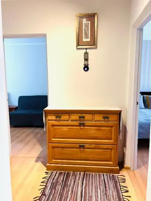 a wooden dresser in a room with a blue couch at Comfy classic apartment in Trakai in Trakai