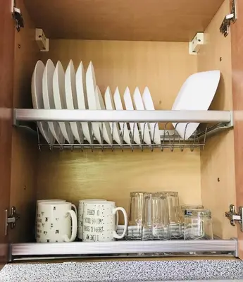 a shelf filled with plates and mugs in a kitchen at Comfy classic apartment in Trakai in Trakai