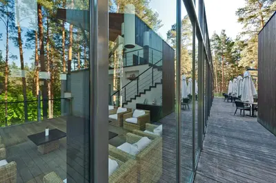 an external view of a house with glass walls at Belvilis Hotel in Molėtai