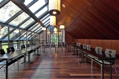 a large room with tables and chairs in a building at Belvilis Hotel in Molėtai