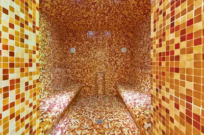 a tiled room with benches in a brick wall at Belvilis Hotel in Molėtai