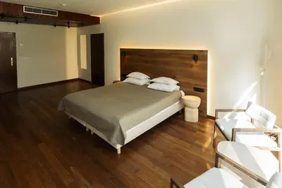 a bedroom with a large bed and a couch at Belvilis Hotel in Molėtai