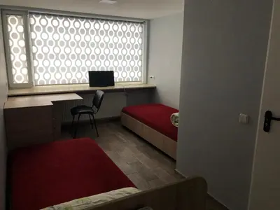 a room with a window and a desk with a laptop at Hostel Laurita in Kaunas