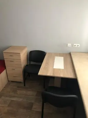 a room with a table and two chairs and a cabinet at Hostel Laurita in Kaunas