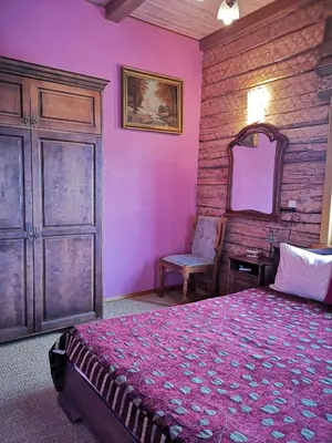 a bedroom with a bed and a chair and a mirror at Vila Marta in Druskininkai
