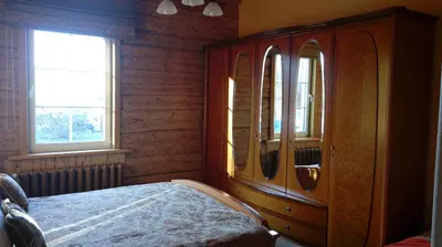 a bedroom with a wooden dresser and a mirror at Vila Marta in Druskininkai