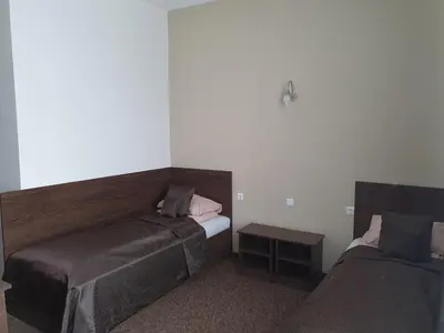 a hotel room with two beds and a table at Svetainė in Jonava