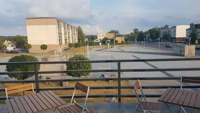 an empty parking lot with chairs and a building at Svetainė in Jonava