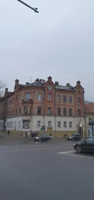 a large brick building with cars parked in a parking lot at senamiescio deimantas in Vilnius