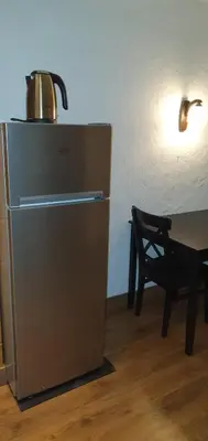 a refrigerator with a pot on top of it next to a table at senamiescio deimantas in Vilnius
