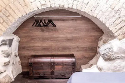 a room with a wooden wall with a suitcase at UNESCO Hidden Arches – Restored 3 Bedroom Apartment in the Historic Pilies St. in Vilnius
