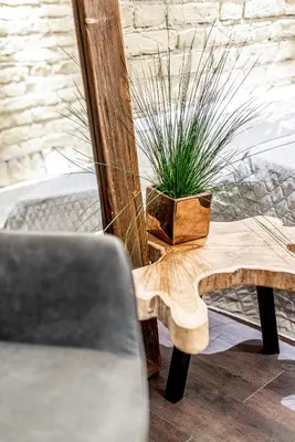 a wooden table with a potted plant on it at UNESCO Hidden Arches – Restored 3 Bedroom Apartment in the Historic Pilies St. in Vilnius