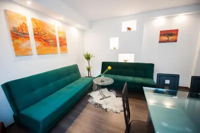 a living room with a green couch and a table at Vilnius Old Town, 3 BDR Penthouse, 100 m2 with Terrace in Vilnius