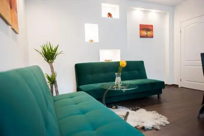 a living room with a green couch and a table at Vilnius Old Town, 3 BDR Penthouse, 100 m2 with Terrace in Vilnius