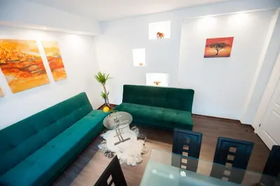 a living room with a green couch and a table at Vilnius Old Town, 3 BDR Penthouse, 100 m2 with Terrace in Vilnius