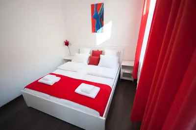 a white bed with red blanket and white pillows at Romantic New 2 Bedroom Vilnius Best Location in Vilnius