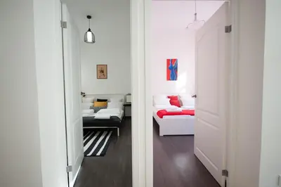 a room with white walls and a living room with a couch at Romantic New 2 Bedroom Vilnius Best Location in Vilnius