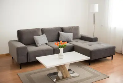 a living room with a couch and a table with flowers at Petro delux apartments center in Kaunas