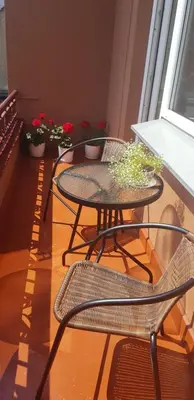a balcony with two tables and chairs and potted plants at Petro delux apartments center in Kaunas