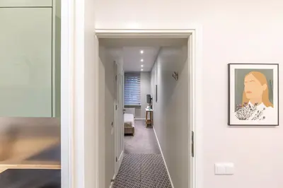 a hallway leading to a room with a painting on the wall at Art & Comfort Rooms in Kaunas